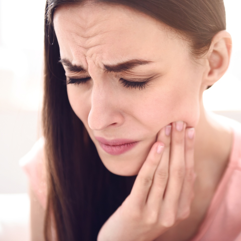 Do not wait for consequences. Portrait of beautiful sick woman holding touching her jaw and feeling pain while having a toothache