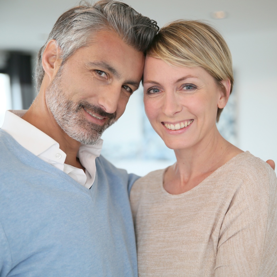 Smiling middle-aged couple standing in brand new home