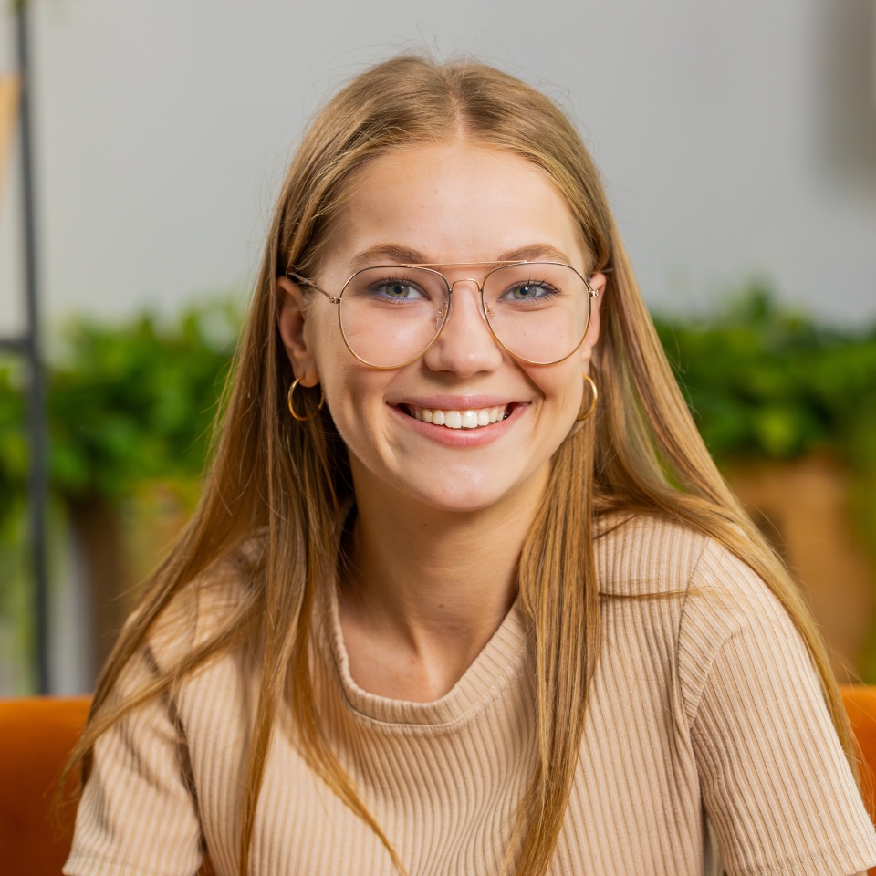 Portrait of happy calm young woman at home couch smiling friendly, glad expression looking away dreaming resting, relaxation feel satisfied concept good news, celebrate win. Girl on living room sofa
