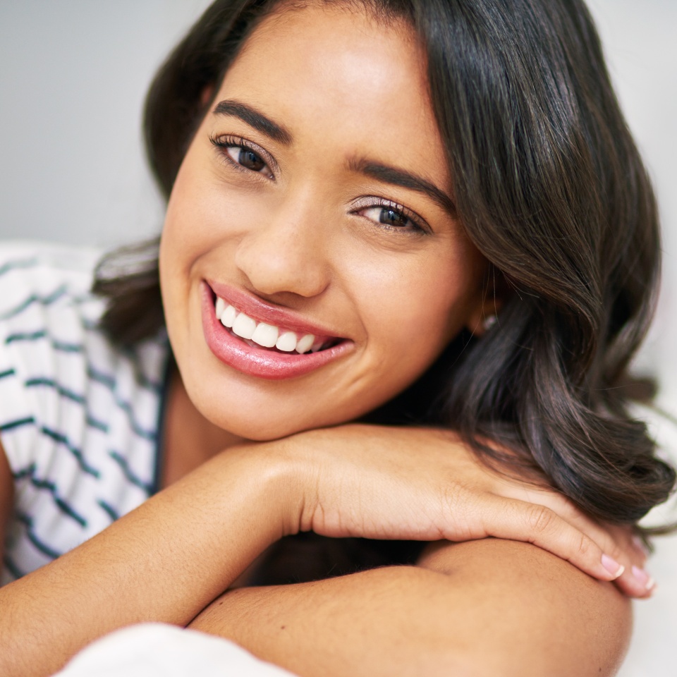 Portrait, relax and girl on couch, comfort and home with happiness, calm and weekend break. Face, apartment and person on sofa, cheerful or peace with lounge, wellness and house with smile or woman