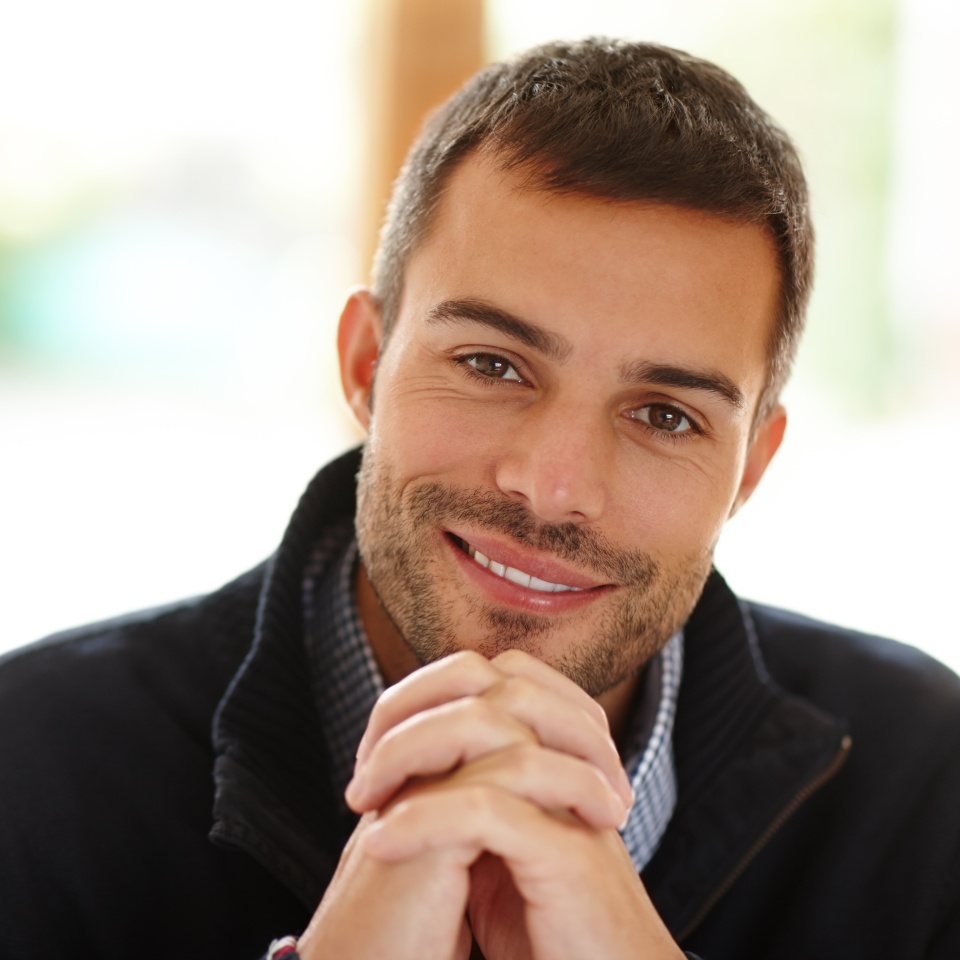 Portrait, happy man and hands in house for peace with smile, relax and self care. Calm, happiness and smiling face of male person in apartment lounge for wellness, natural light and casual comfort