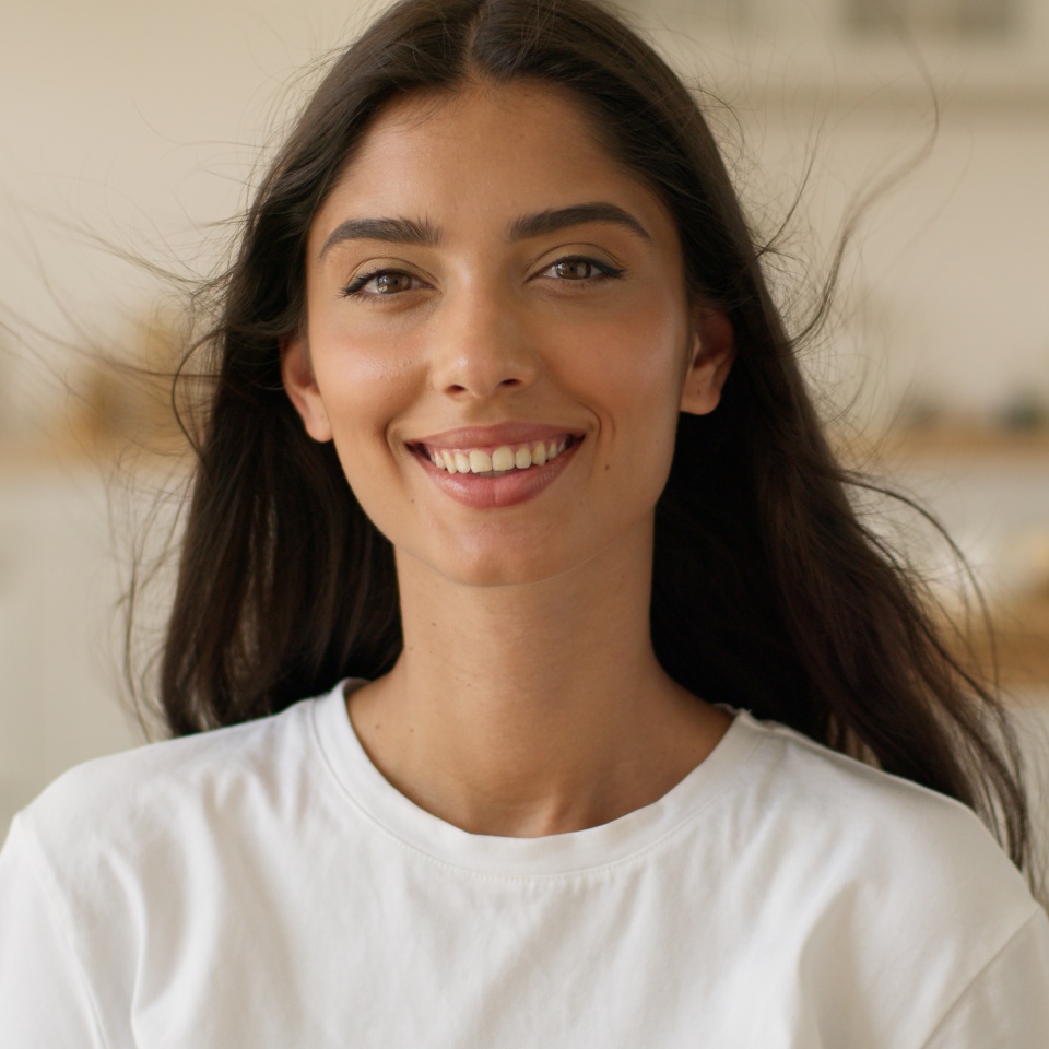 Happy smiling positive beautiful woman Indian Arabian girl female lady toothy healthy smile attractive pretty at home gorgeous hair smooth hairstyle color hairdo blow wind air conditioner ventilation