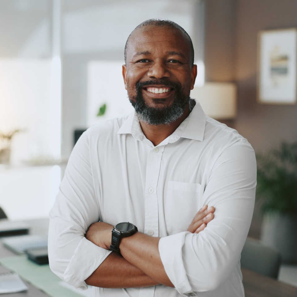 Mature, portrait or black man with arms crossed in office as confident project manager for development. Opportunity, smile or proud entrepreneur in startup company with mission or business commitment